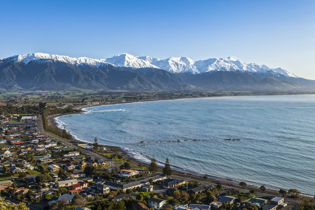 Aerial view of Kaikoura township, the sweeping coastline and the snow-capped Seaward Kaikoura Range